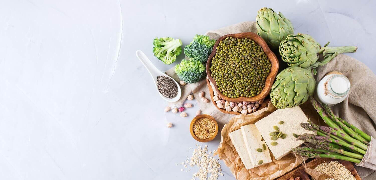 A top down view of some protein alternatives in food. Beans, Peas, broccoli, nuts, lentils, etc.