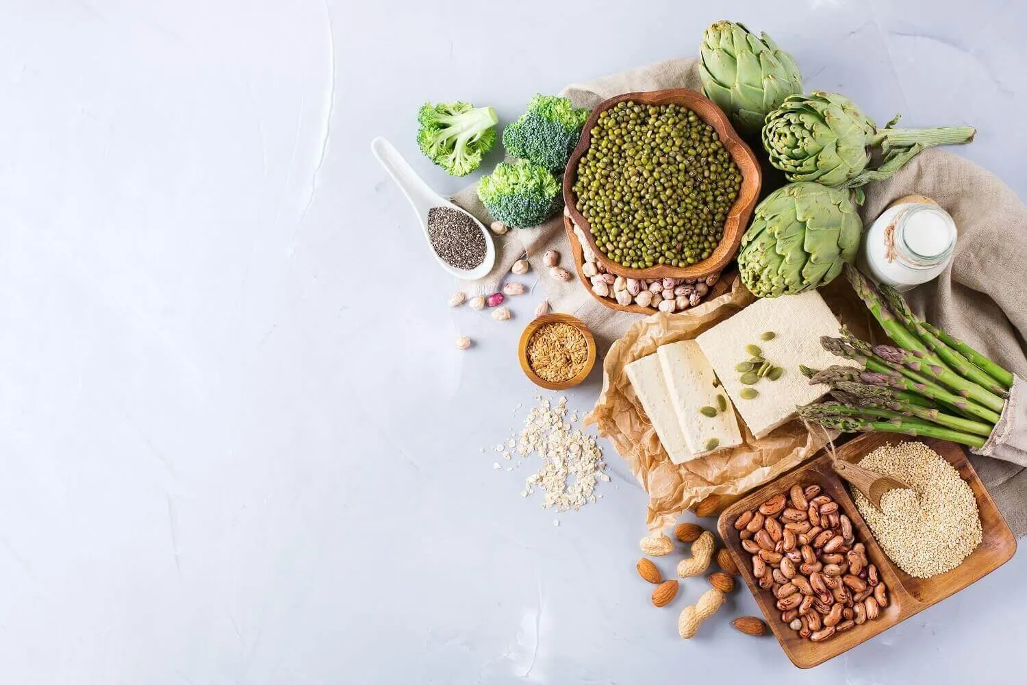 A top down view of some protein alternatives in food. Beans, Peas, broccoli, nuts, lentils, etc. 
