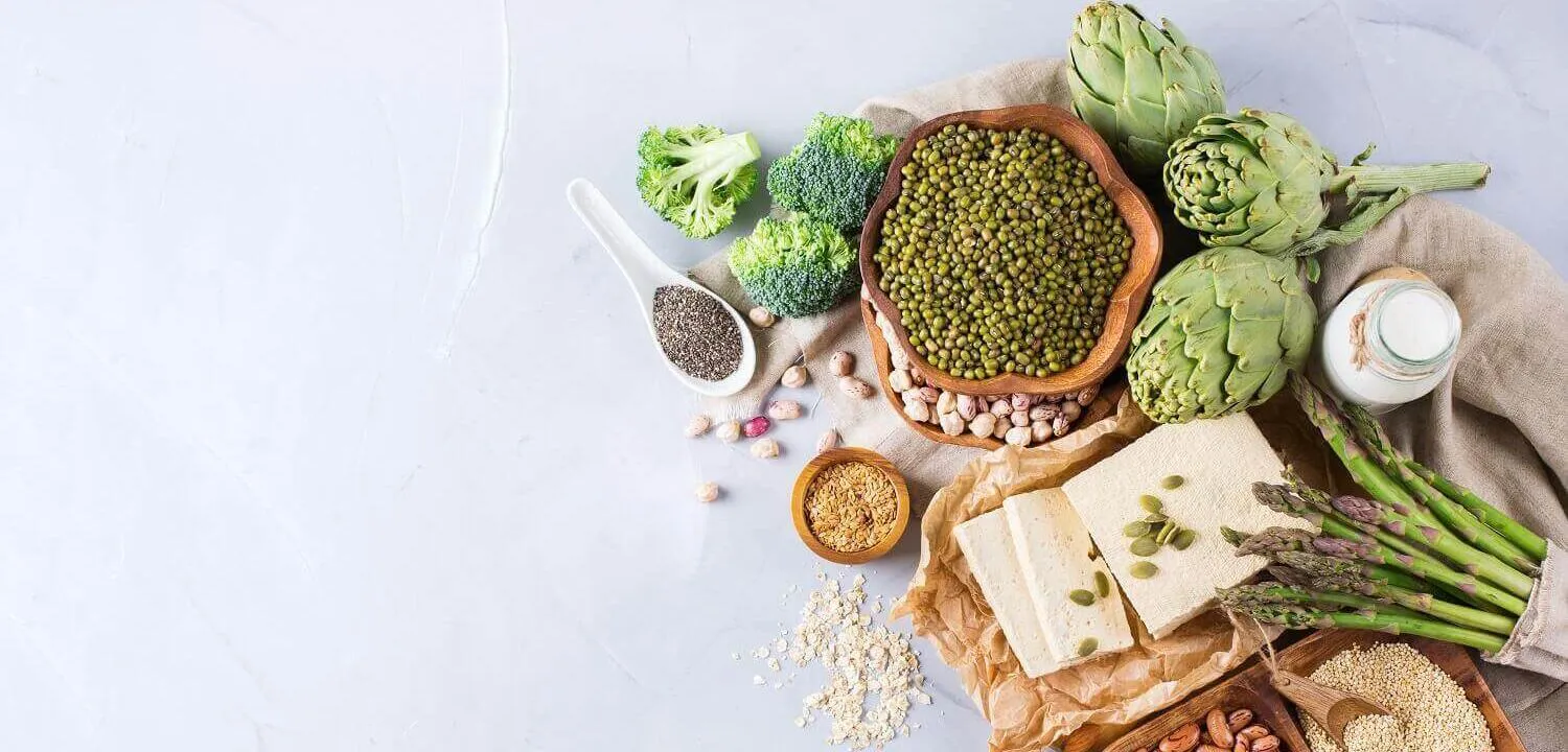 A top down view of some protein alternatives in food. Beans, Peas, broccoli, nuts, lentils, etc.