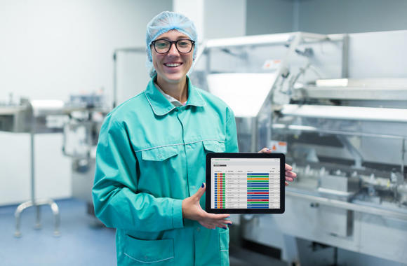 Technicus van Domino toont op een tablet informatie over de productielijn