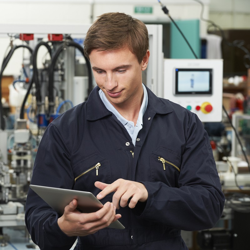 Man in boilersuit looking at tablet 