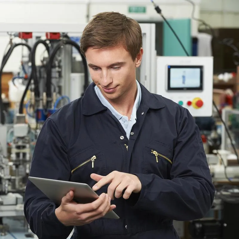 Man in boilersuit looking at tablet 