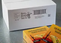 A white porous cardboard box with a Cx150i code printed on the outside as well as some boxes of taco shells.