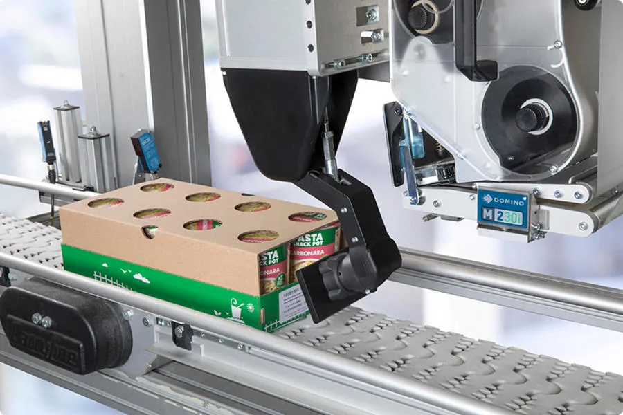 자동라벨부착기로 박스 트레이에 라벨 부착하는 모습