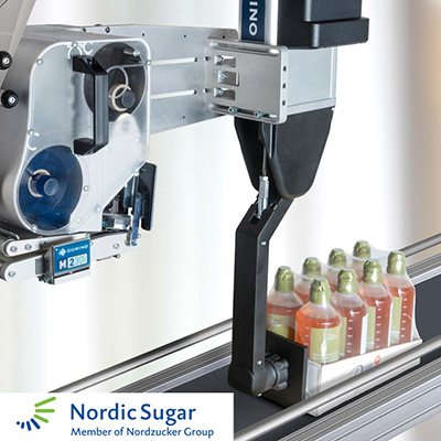 M230i-S4 de Domino aplicando etiqueta sobre bandeja empaquetada de Nordic Sugar