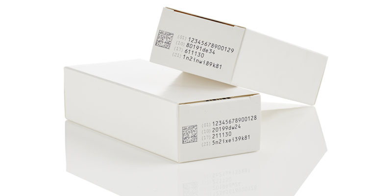Code noir d'une imprimante à jet d'encre thermique sur un carton pharmaceutique blanc