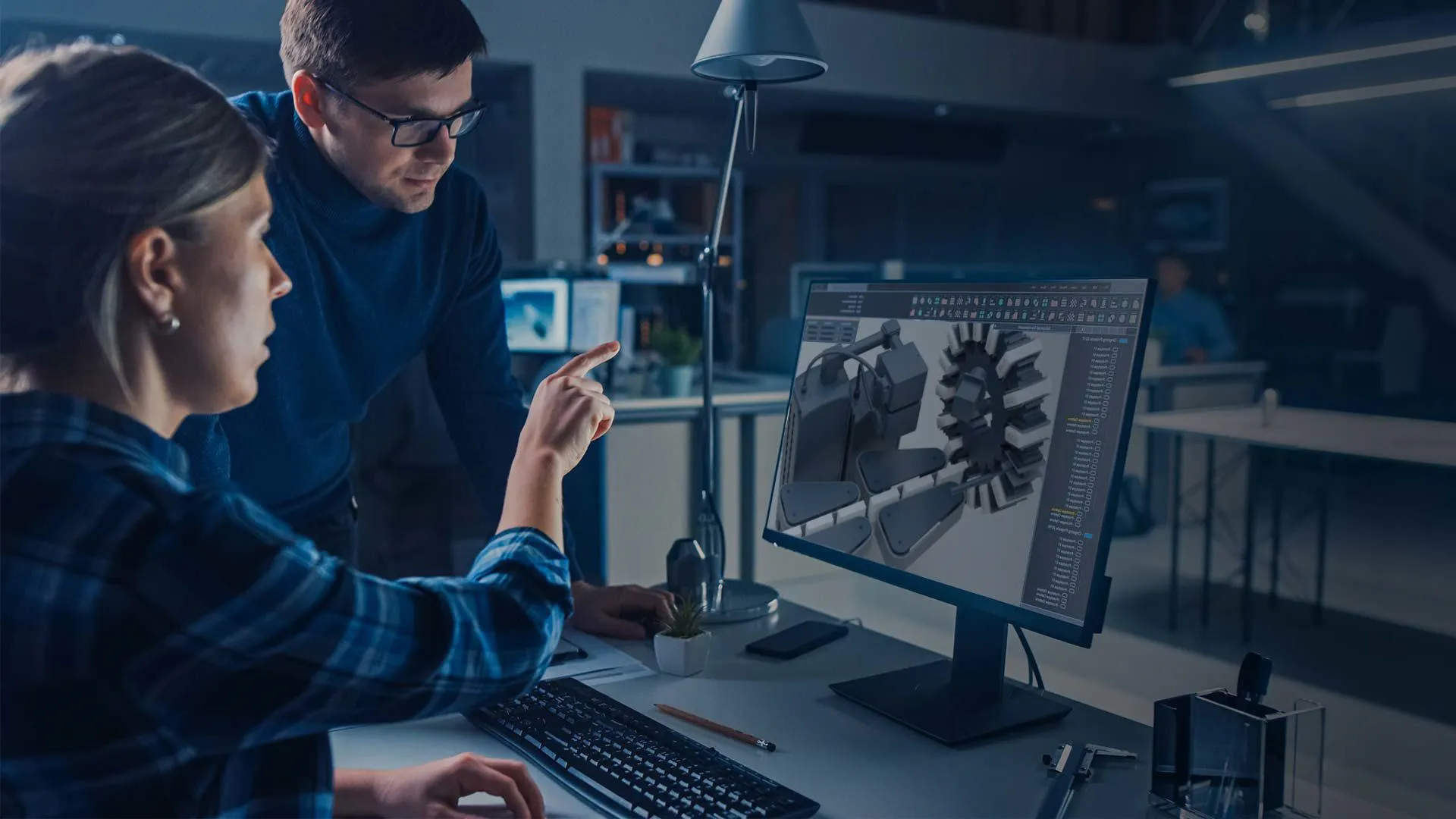 A woman showing a man a production line on a computer screen